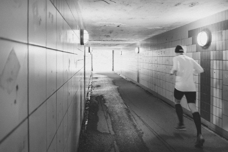 Back of man running in a tunnel